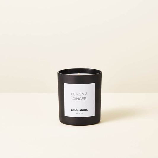 An ambustum lemon and ginger candle presented in a black glass candle  with white labelling.  Scent profile Sicilian lemons, tangy lemon grass and juicy limes complimented by spicy ginger root and grated nutmeg, with a hint of refreshing eucalyptus.