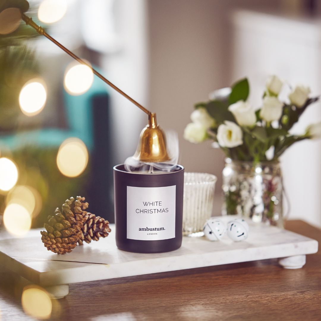 An ambustum White Christmas candle presented in a black glass candle with white labelling. Fill your home with a scent which captures the magic of Christmas. Notes clove and pine are softened with warm caramel and complimented by top notes of raspberry and orange.